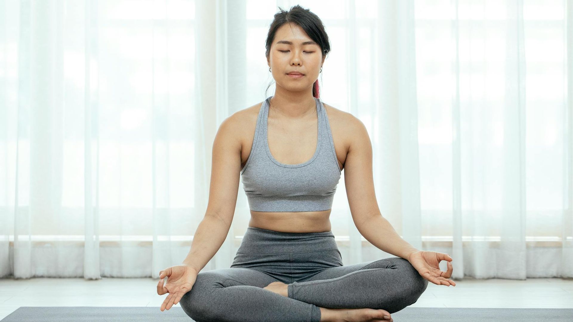 Serene yoga studio environment with soft morning light filtering through windows.