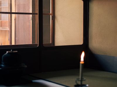 Warm candle light and a wooden floor in a calm room.